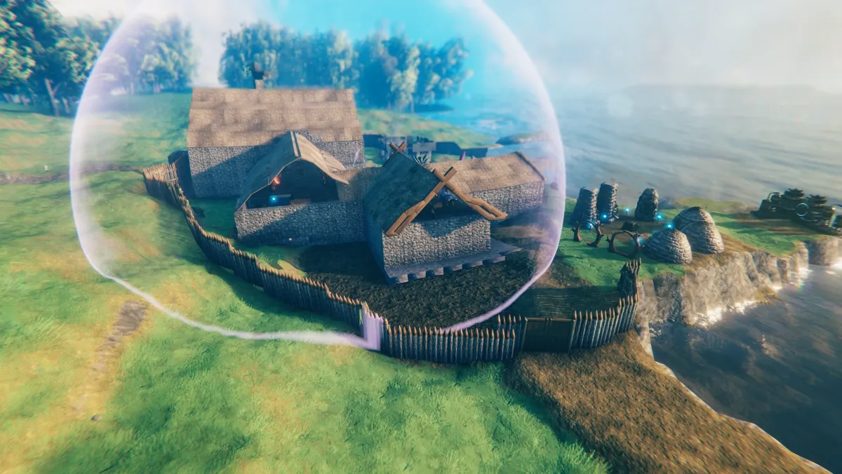 A Valheim base with longhouses behind a wooden wall, on a cliff by the sea